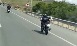 Uzanarak motosiklet kullanan sürücü tehlikeye davetiye çıkardı
