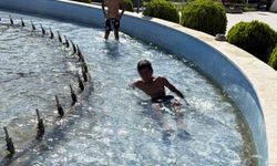 Sıcaklardan bunalan çocuklar süs havuzunda serinledi