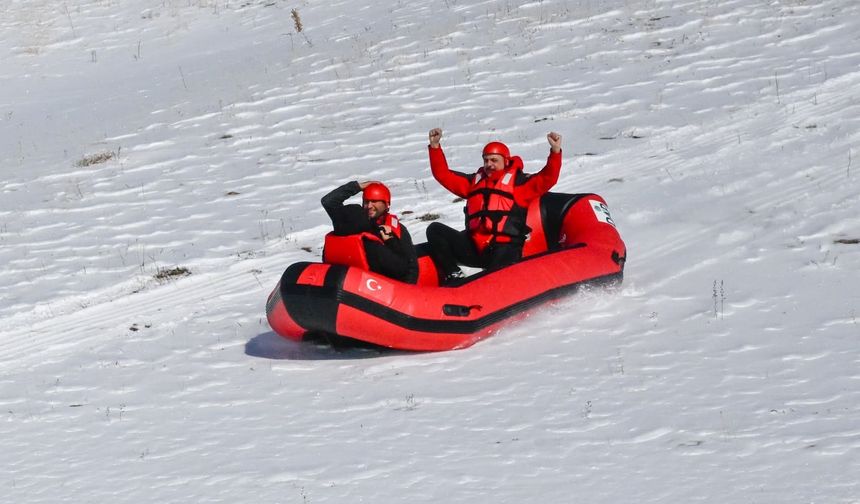 Karla kaplı dağdan donmuş gölete botla kaydılar